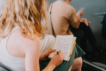 Attendees writing notes during a conference session